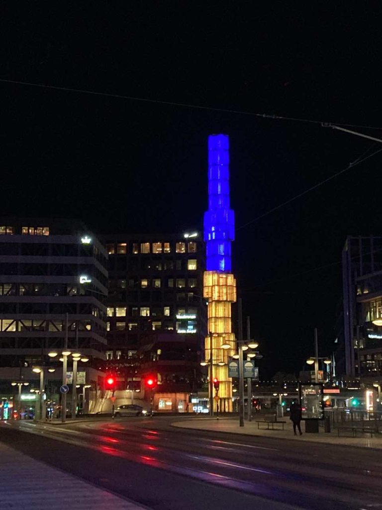 Ο γυάλινος οβελίσκος φωτισμένος με τα χρώματα της σημαίας της Σουηδίας τη νύχτα στο κέντρο της πλατείας Σέργκελς Τόργκ στη Στοκχόλμη