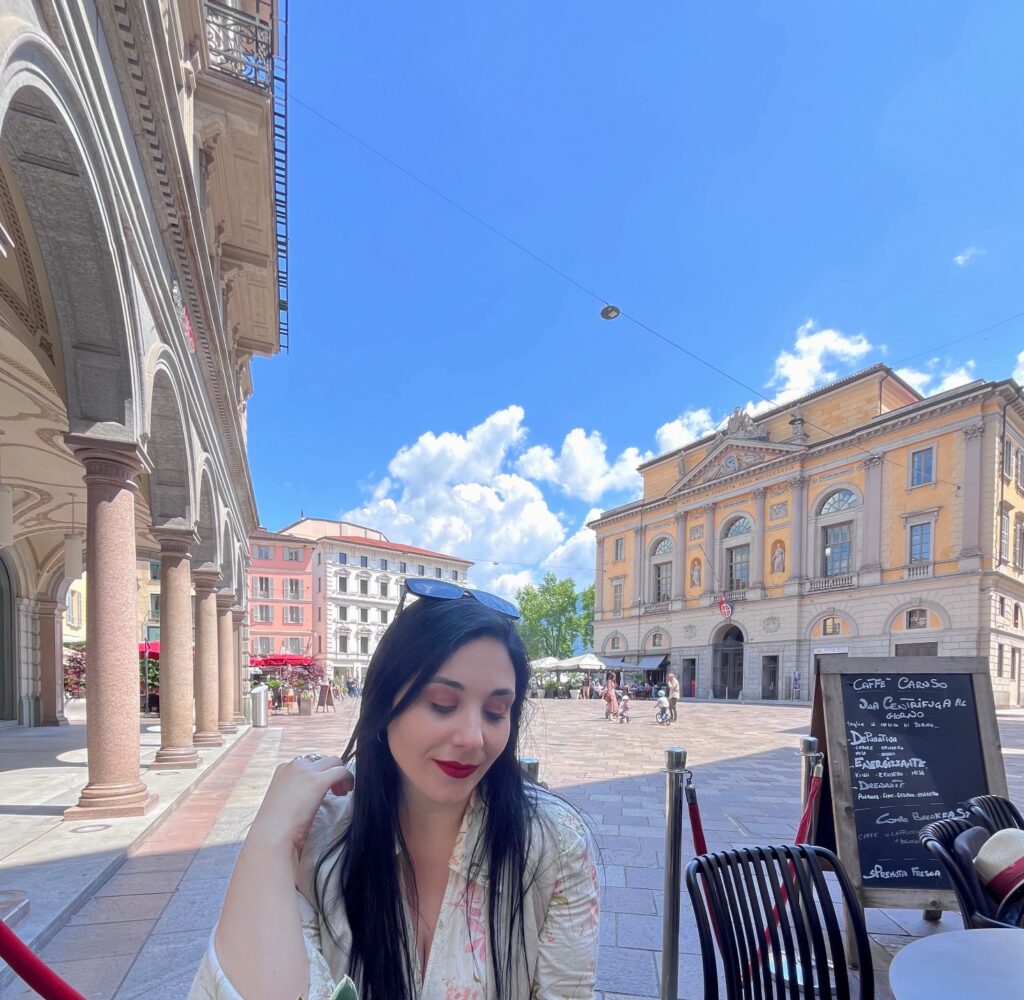 Travel blogger Eleni Kotidou (worldtravellen) with Lugano's main square, Piazza della Riforma, in the background