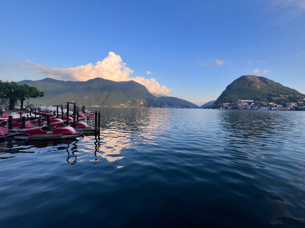 Red boats moored at the dock on Lake Lugano, Switzerland
