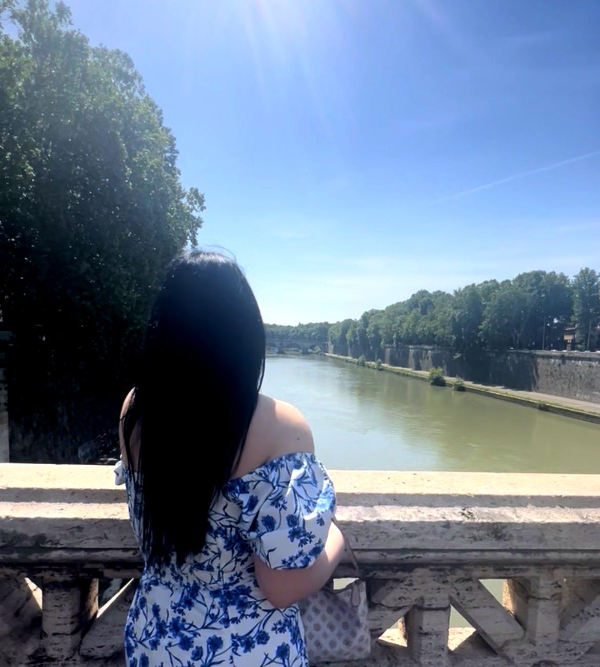 Η travel blogger Worldtravellen σε ιστορική γέφυρα πάνω από τον ποταμό Τίβερη στη Ρώμη, Ιταλία